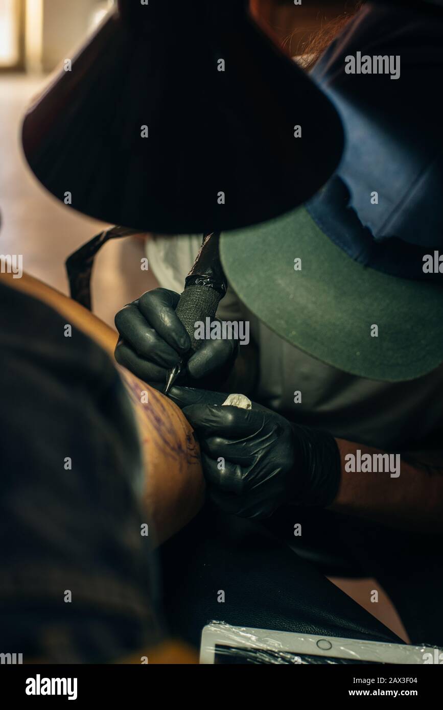 Un Artista Profesional Del Tatuaje Introduce Tinta Negra En La Piel Con Una  Aguja De Una Máquina De Tatuaje. Fotos, retratos, imágenes y fotografía de  archivo libres de derecho. Image 89451989
