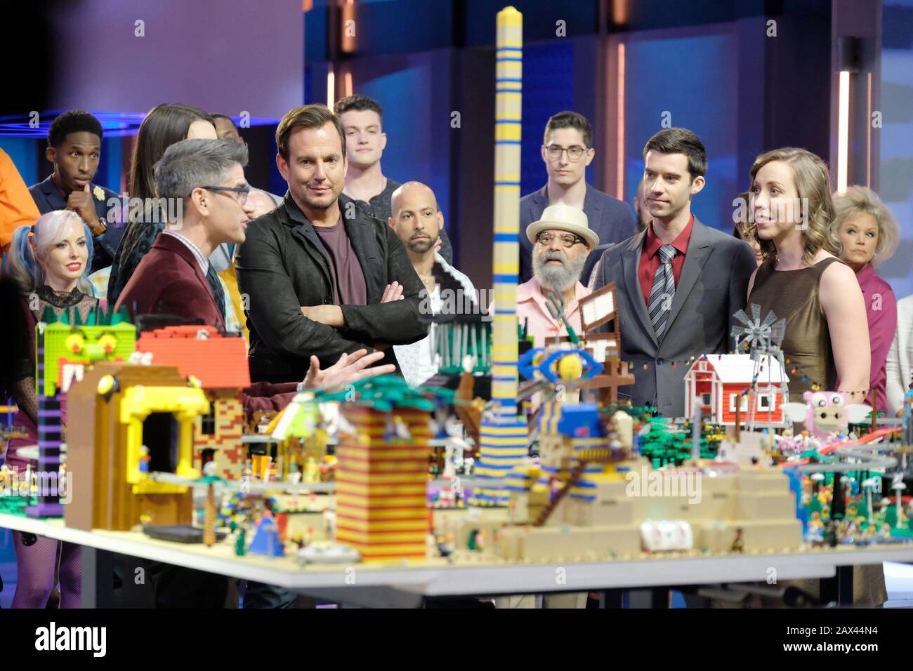 LEGO MASTERS, el juez Jamie Berard (segundo de la izquierda) y el anfitrión  Arnet (tercero de la izquierda) rodeado de concursantes, piloto ,  (Temporada 1, episodio 101, emitido el 5 de febrero