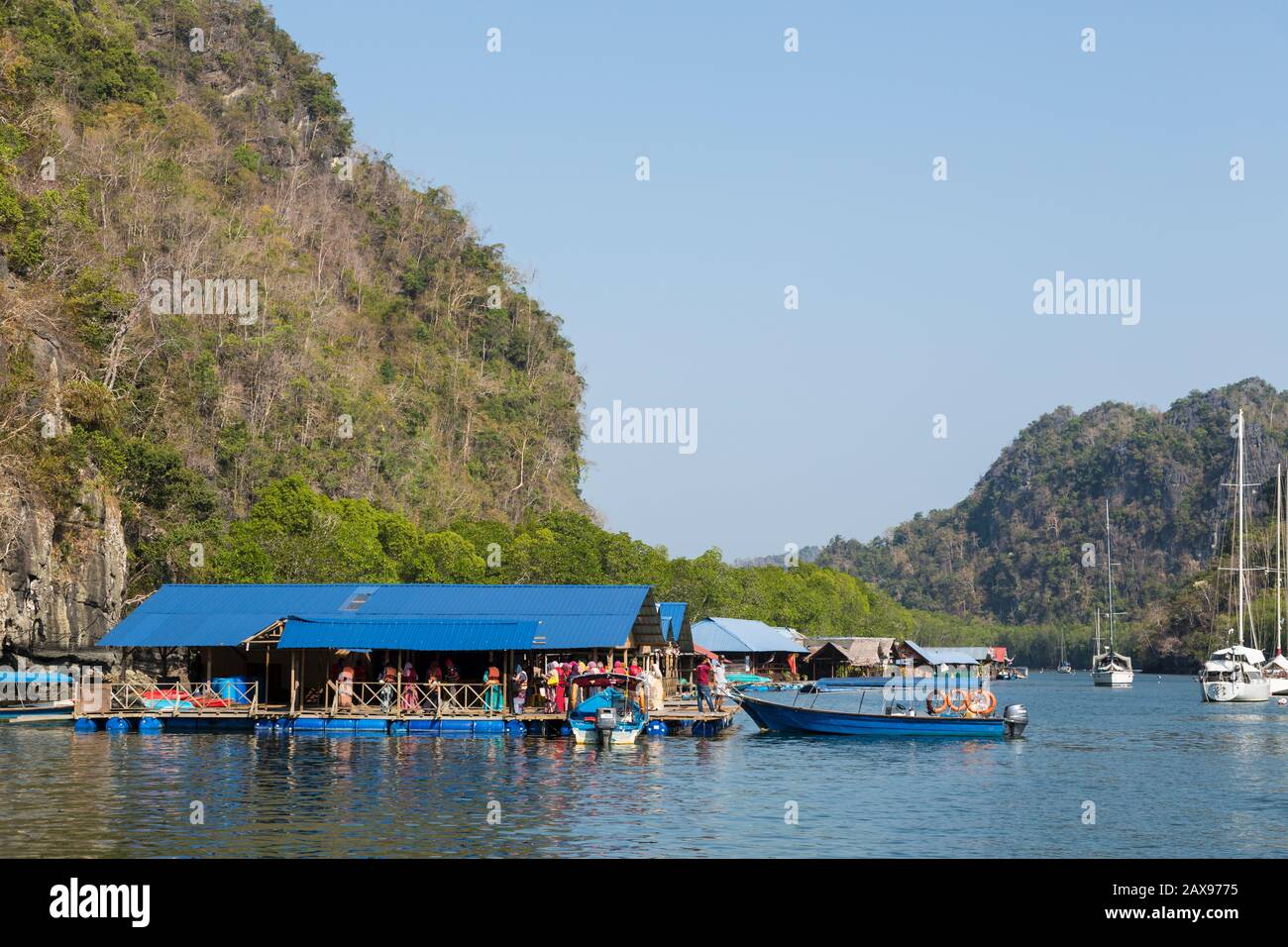 Los barcos llevan a turistas musulmanes a la granja de peces Paksu, el parque geoforestal Kilim Karst, Langkawi, Malasia Foto de stock