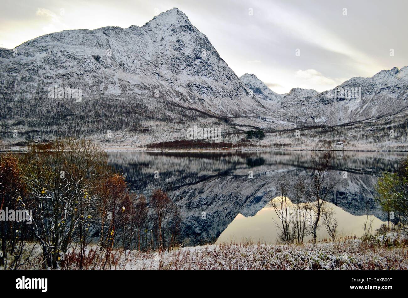 Lago de montaña como el espejo perfecto de la naturaleza situado entre montañas nevadas Foto de stock