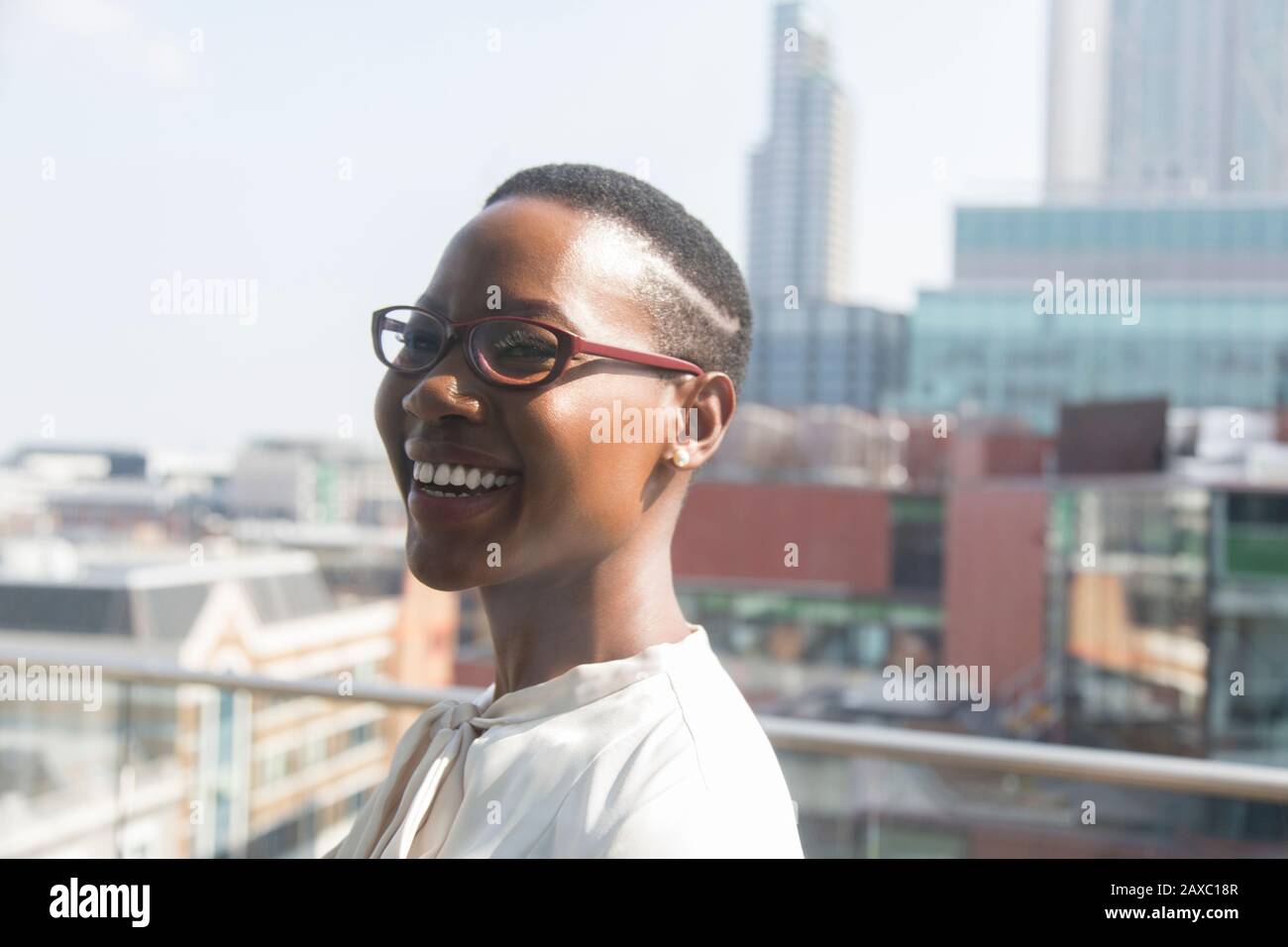 Feliz mujer de negocios en el soleado balcón urbano Foto de stock