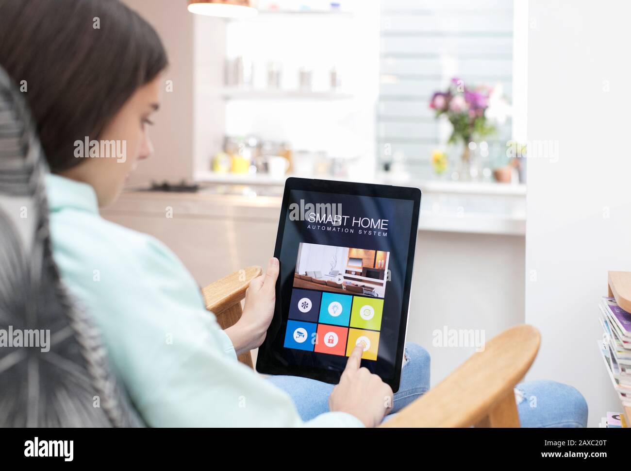 Chica que utiliza el sistema inteligente de automatización doméstica en la tableta digital Foto de stock
