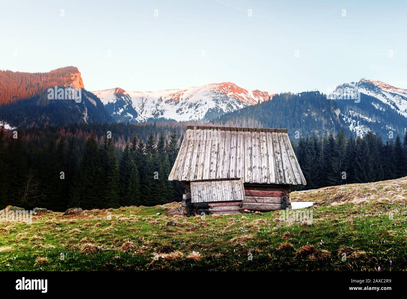 Antigua cabaña de madera y cielo de puesta de sol en las montañas del Alto Tatras en la pradera de Kalatowki, Zakopane, Polonia. Fotografía de paisajes Foto de stock
