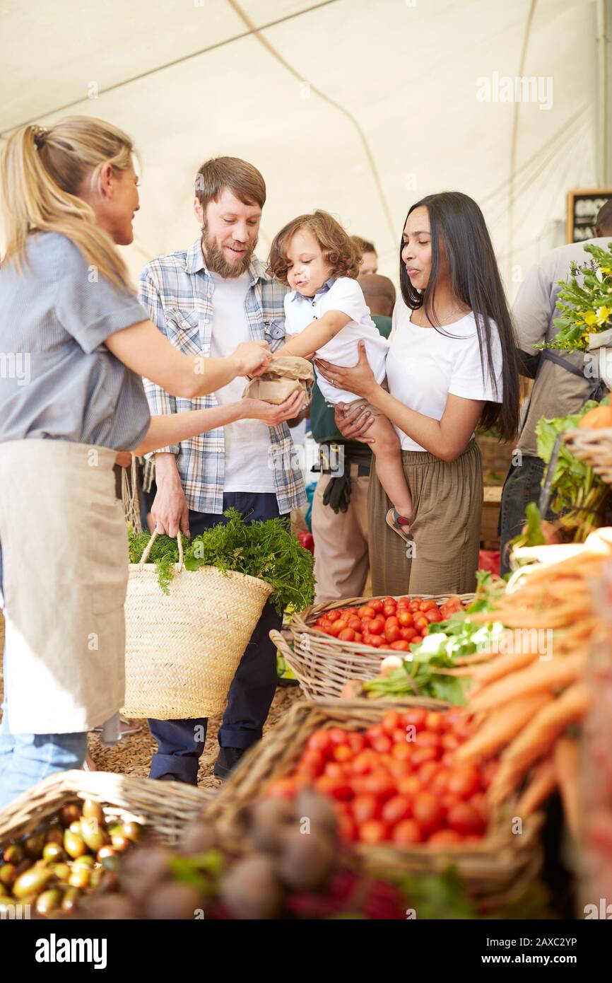 Compras de familias jóvenes en el mercado de agricultores Foto de stock