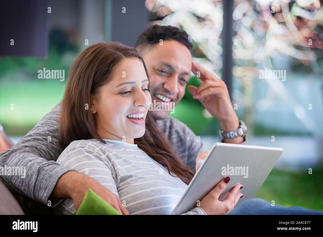 Pareja feliz relajante, con la tableta digital Foto de stock