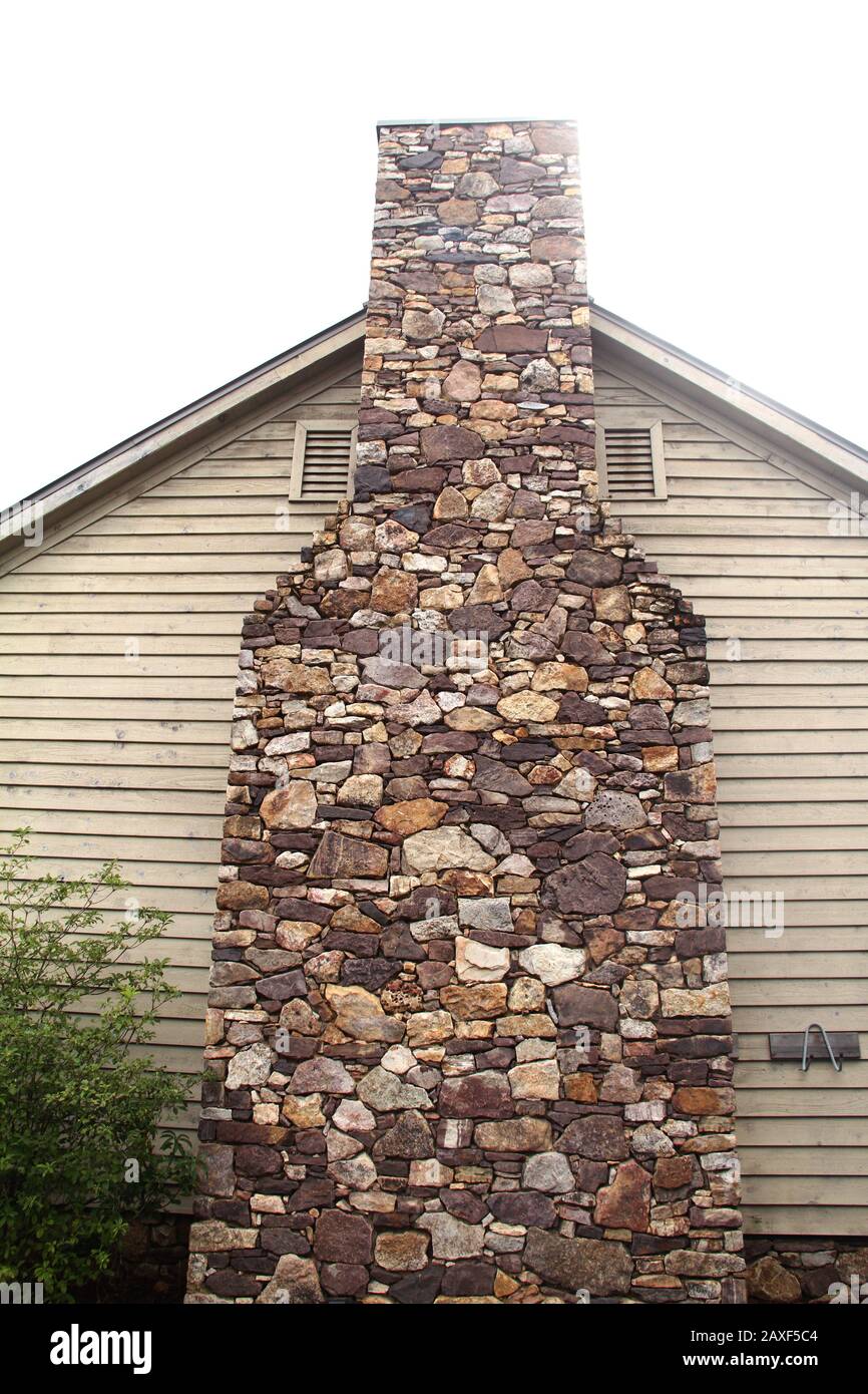 Gran chimenea de piedra en el exterior de una casa de dos pisos Fotografía  de stock - Alamy