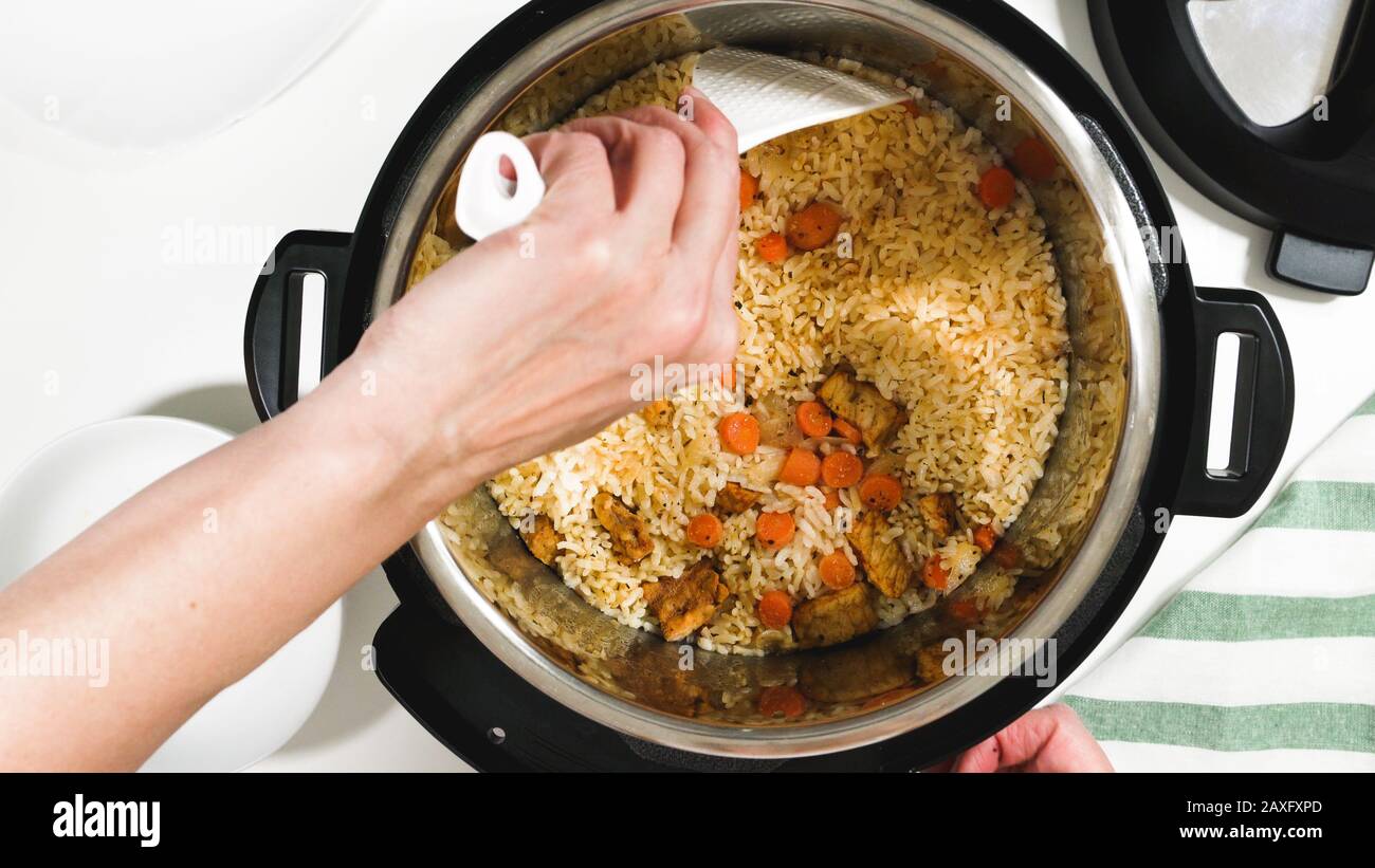 Mezcla de arroz cocido, verduras y carne en una olla. Cocinando arroz con  carne y verduras (o arroz Pilaf) en una olla a presión paso a paso, arriba  v Fotografía de stock -
