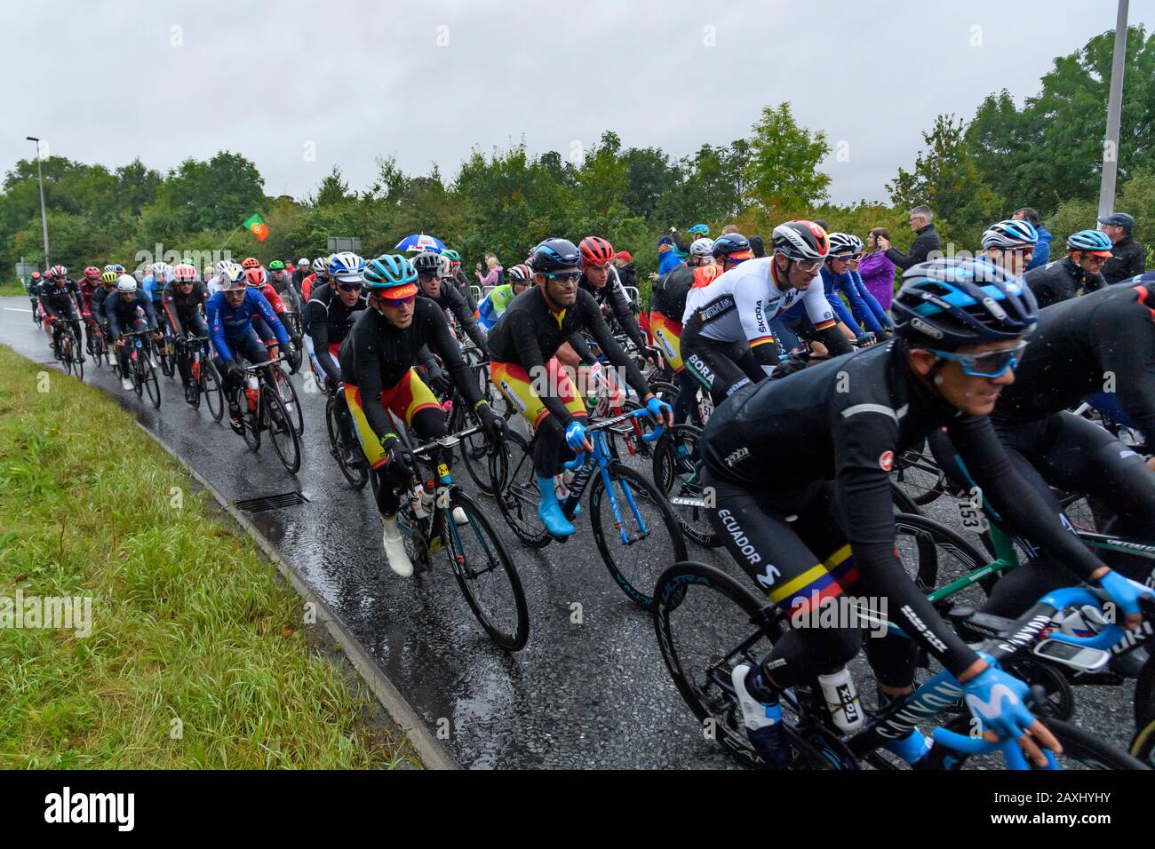 Carreras de bicicleta de carretera para hombres (ciclistas en bicicletas en pelotón) montar y competir en carrera vigilada por los seguidores en la lluvia - Campeonato Mundial UCI, Yorkshire, Reino Unido Foto de stock