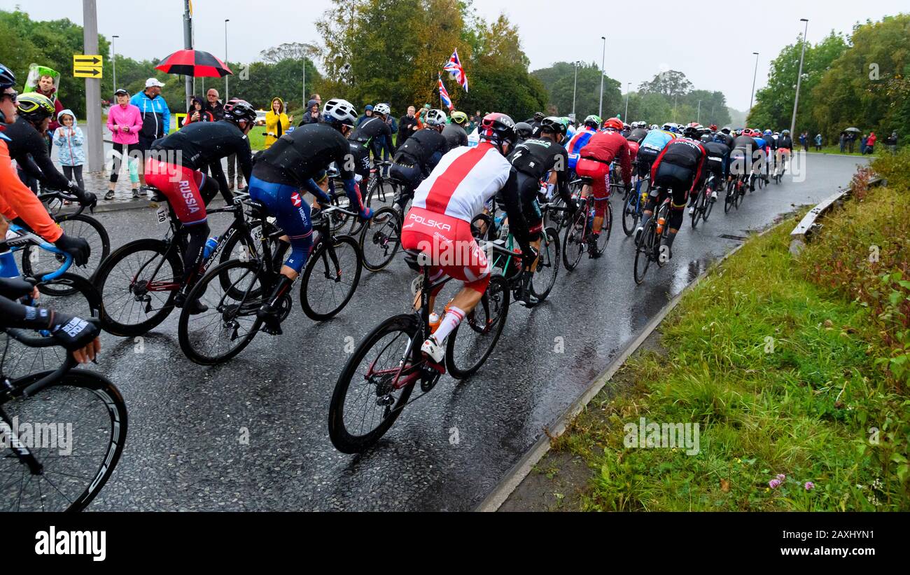 Carreras de bicicleta de carretera para hombres (ciclistas en bicicletas en pelotón) montar y competir en carrera vigilada por los seguidores en la lluvia - Campeonato Mundial UCI, Yorkshire, Reino Unido Foto de stock