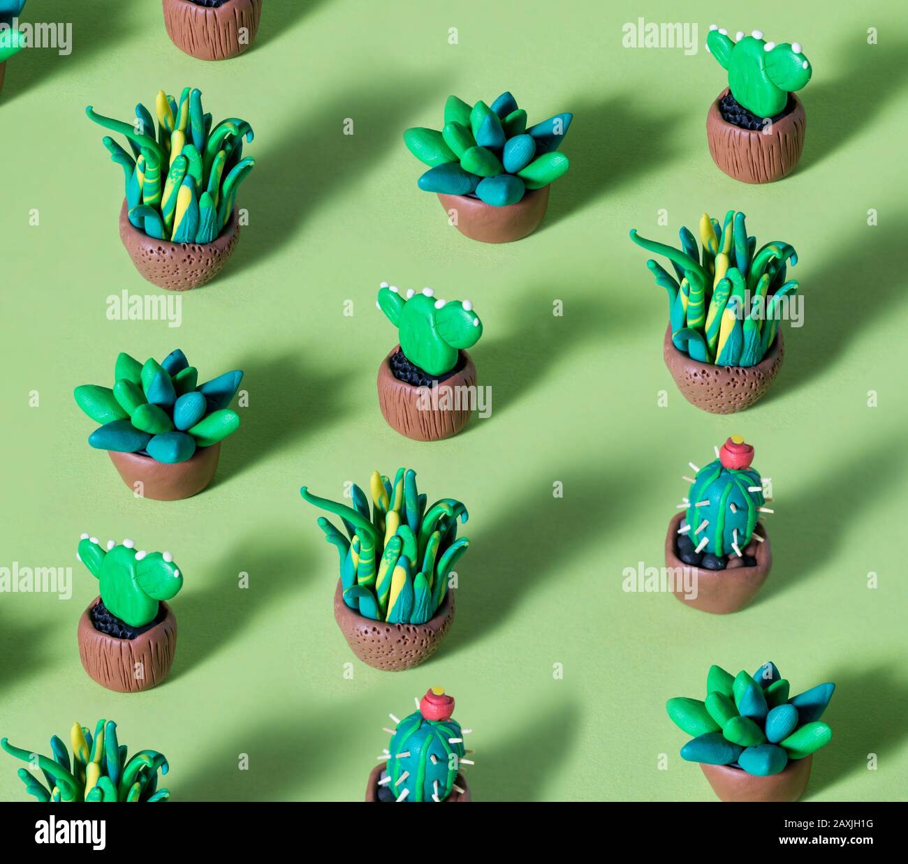 Cactúes y suculentos verdes de plastilina hechos a mano en macetas. Patrón  creativo con figuras de arcilla de cactuses contra fondo de color  Fotografía de stock - Alamy