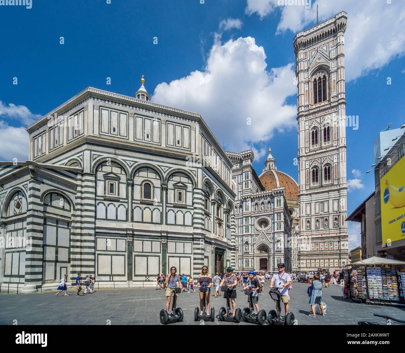 Transportadores personales de dos ruedas en la Piazza del Duomo con el telón de fondo de la Catedral de Florencia con el campanario de Giotto y el Baptisterio de San Juan, Foto de stock