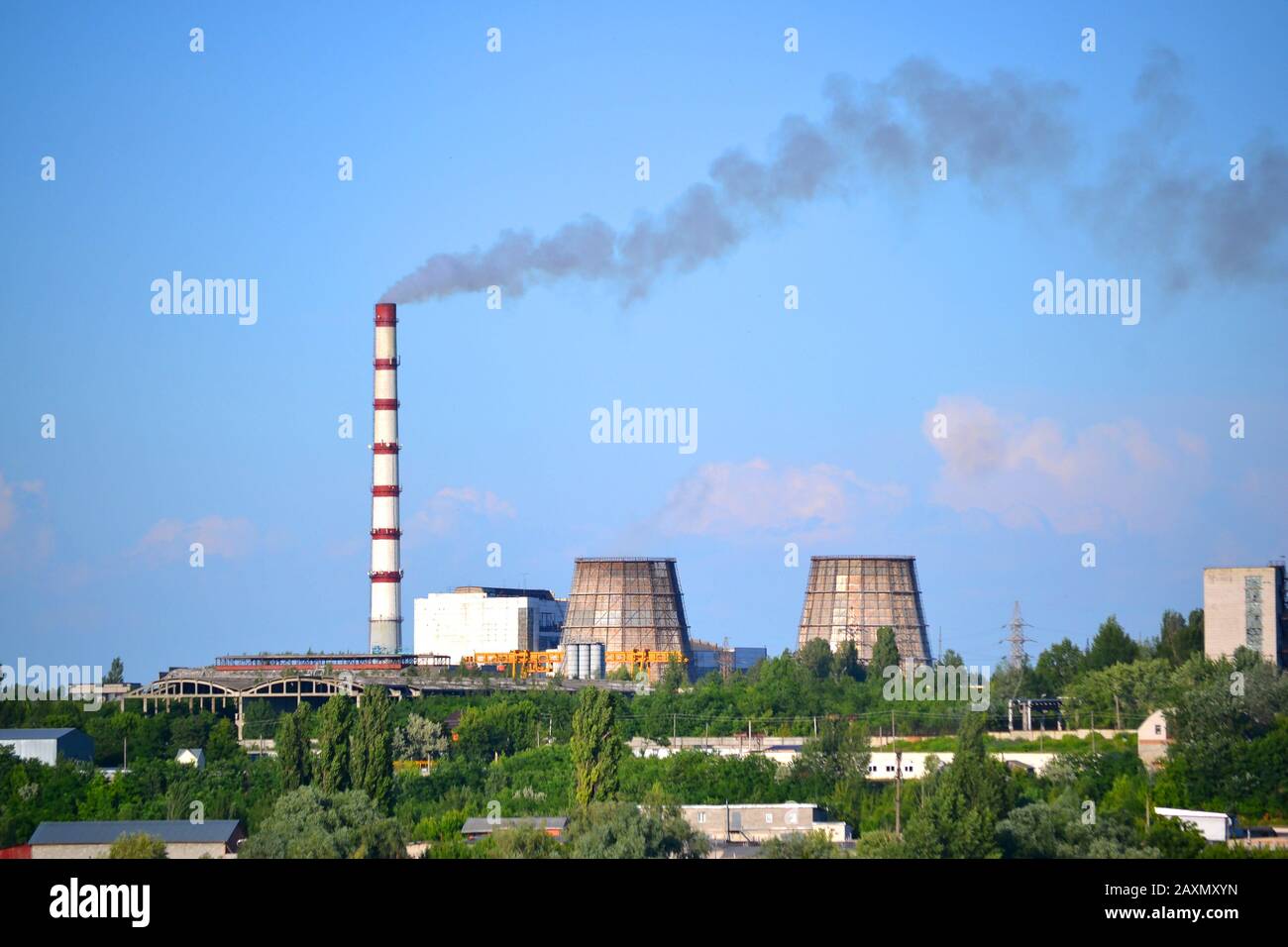 vista de la planta con tuberías y humo en clima soleado Foto de stock