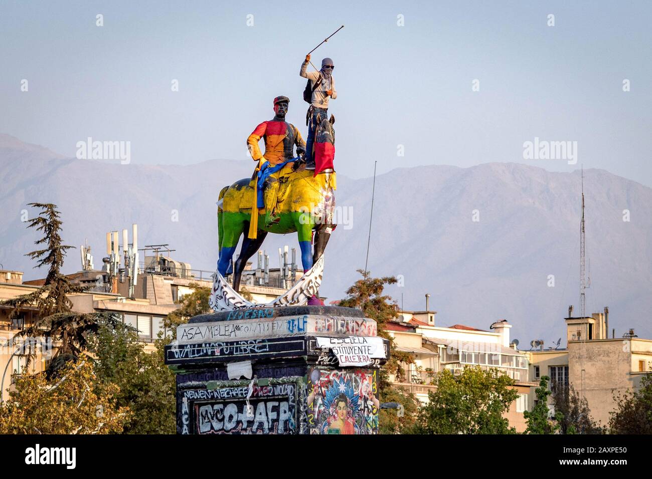 Protestón en la cima de la estatua destrozada en la Plaza de Italia durante las recientes manifestaciones en Santiago de Chile. Foto de stock
