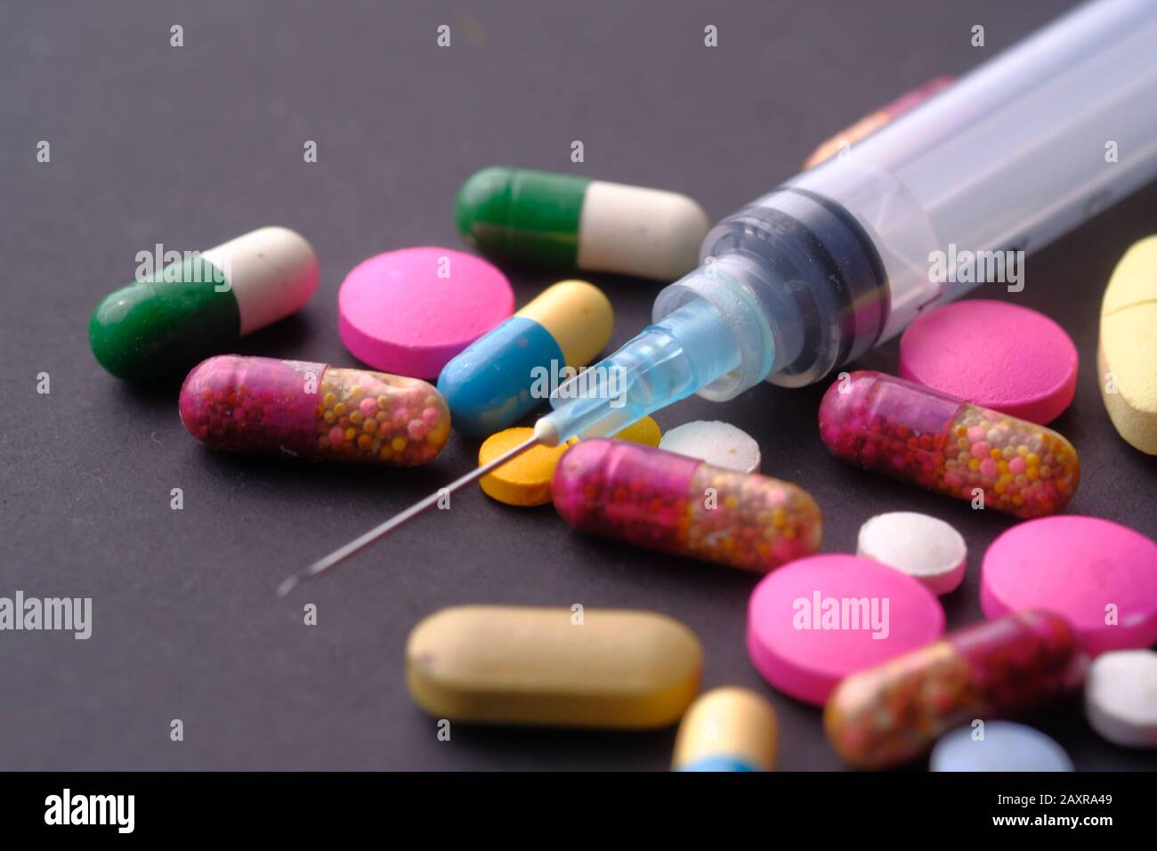 jeringa y pastillas sobre la mesa, abuso de drogas Foto de stock