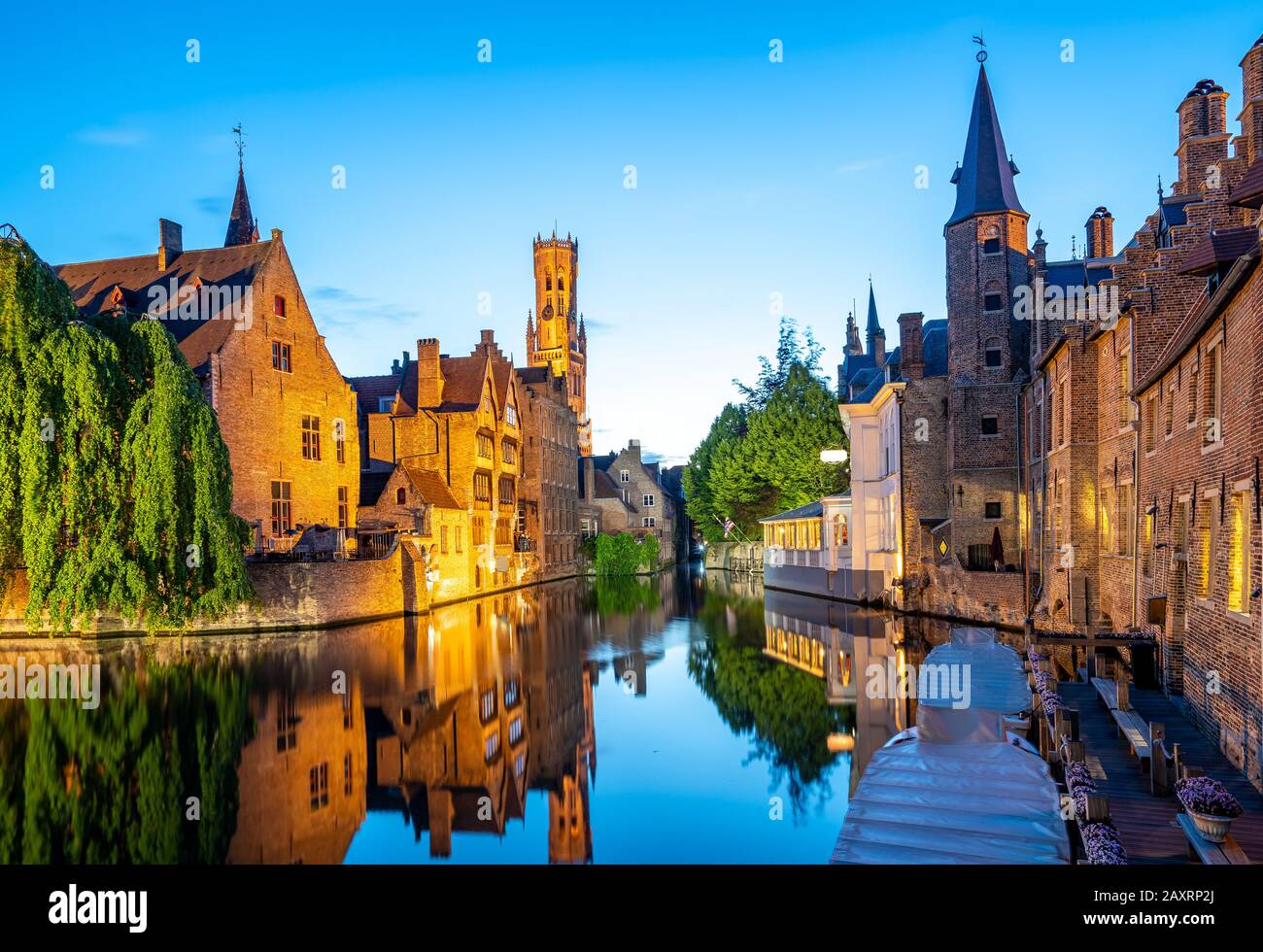 Horizonte de la ciudad de Brujas con canal por la noche en Bélgica. Foto de stock
