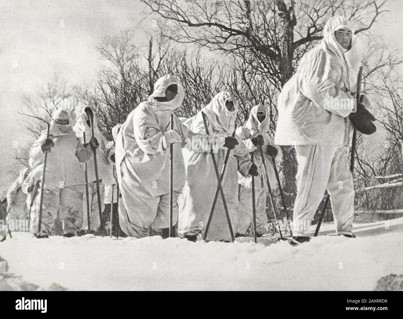 Ejército Rojo en 1930. Del libro de propaganda soviético de 1937. Soldados soviéticos en esquís en abrigos de camuflaje de invierno Foto de stock
