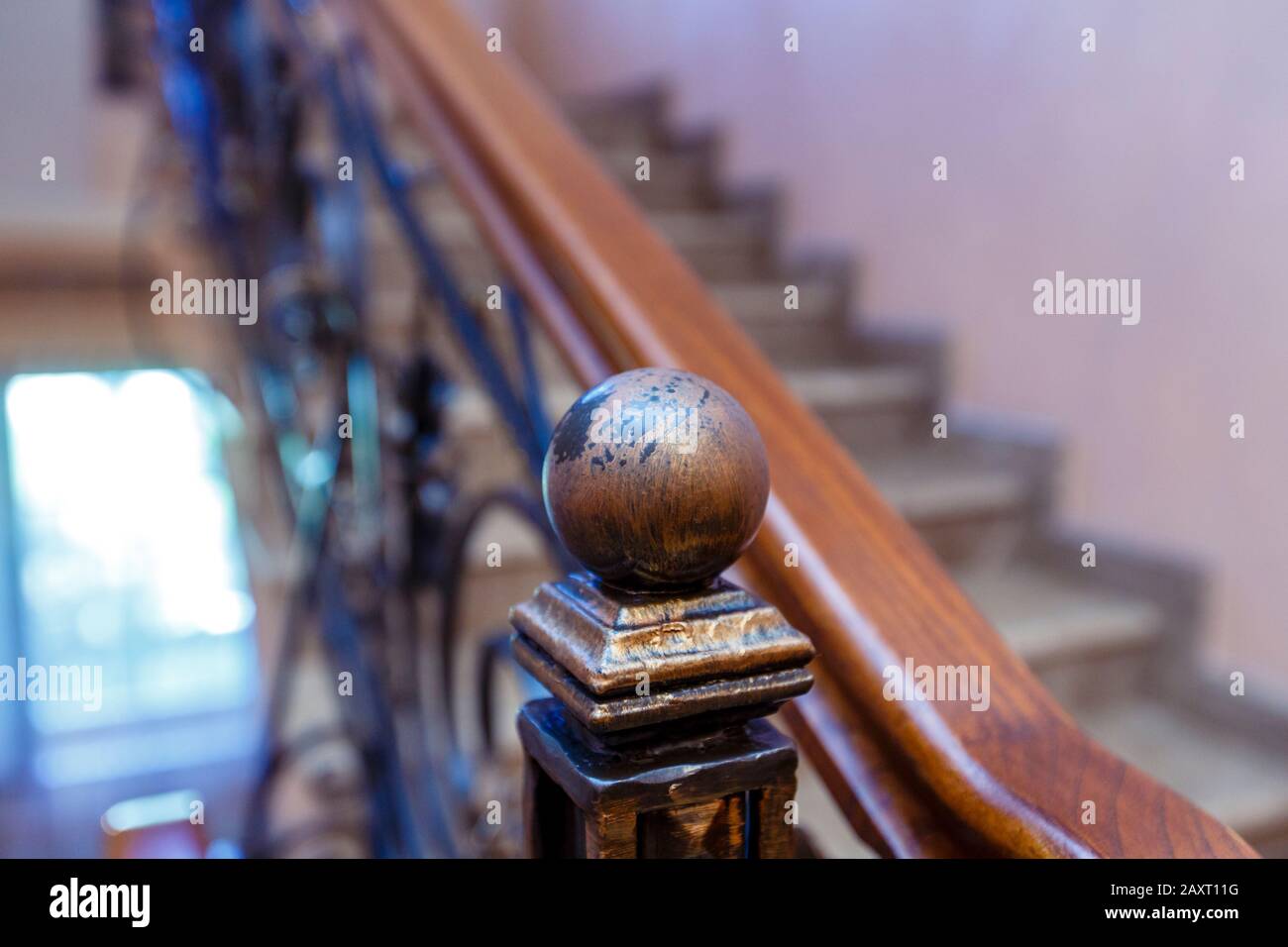 Escaleras, barandilla de madera con un pomo en forma de bola. Escaleras  caras, fondo difuminado Fotografía de stock - Alamy