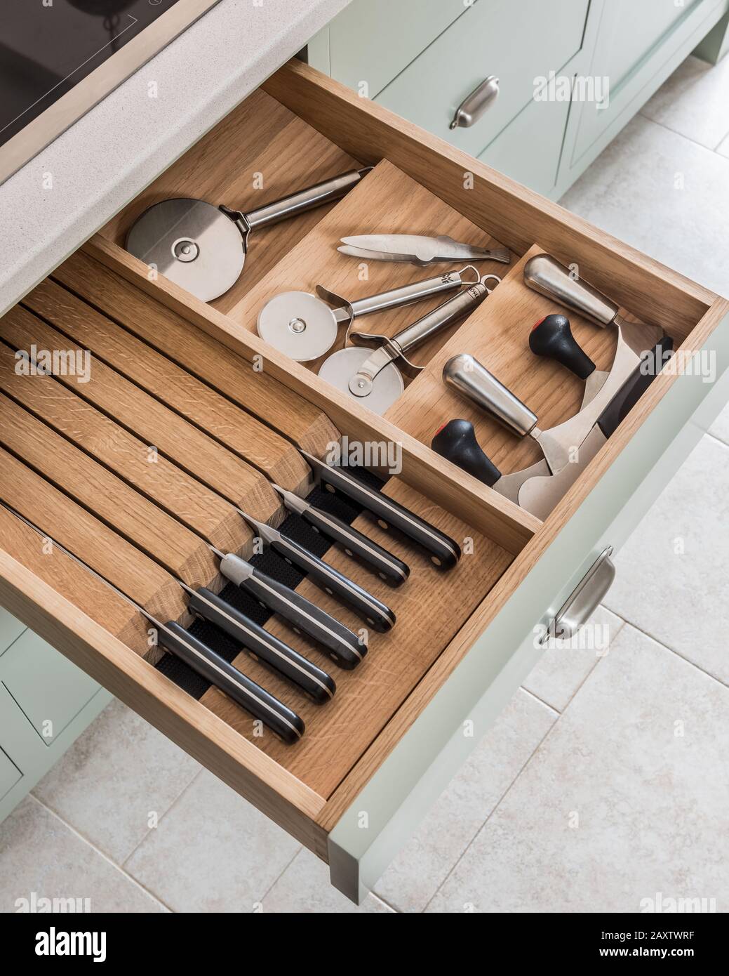 Cuchillos y cortadoras de pizza en cajón de cocina abierto Foto de stock