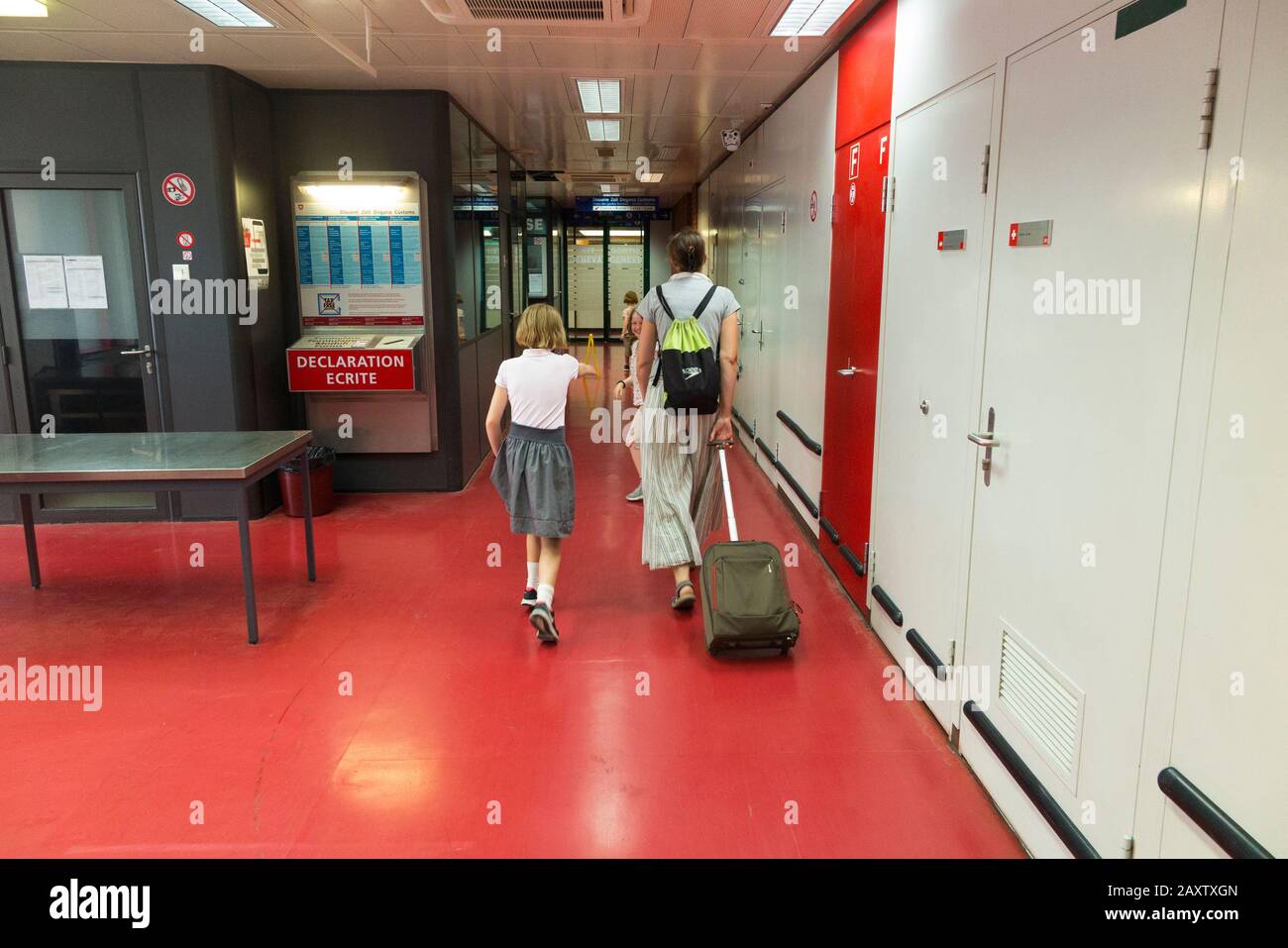 Madre con niños niños / viajeros turistas pasan a través de Aduanas / Douanes en el cruce fronterizo entre Francia y Suiza en la estación de tren de Ginebra. Suiza. (112) Foto de stock
