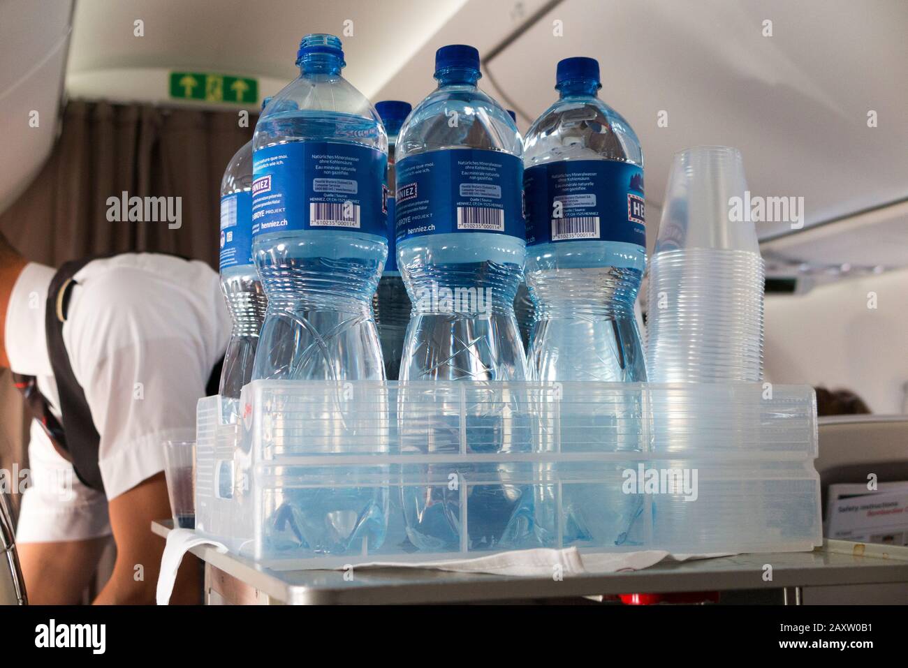 Miembro de la tripulación de cabina con agua bebidas trole entrega refrescos  a los pasajeros de