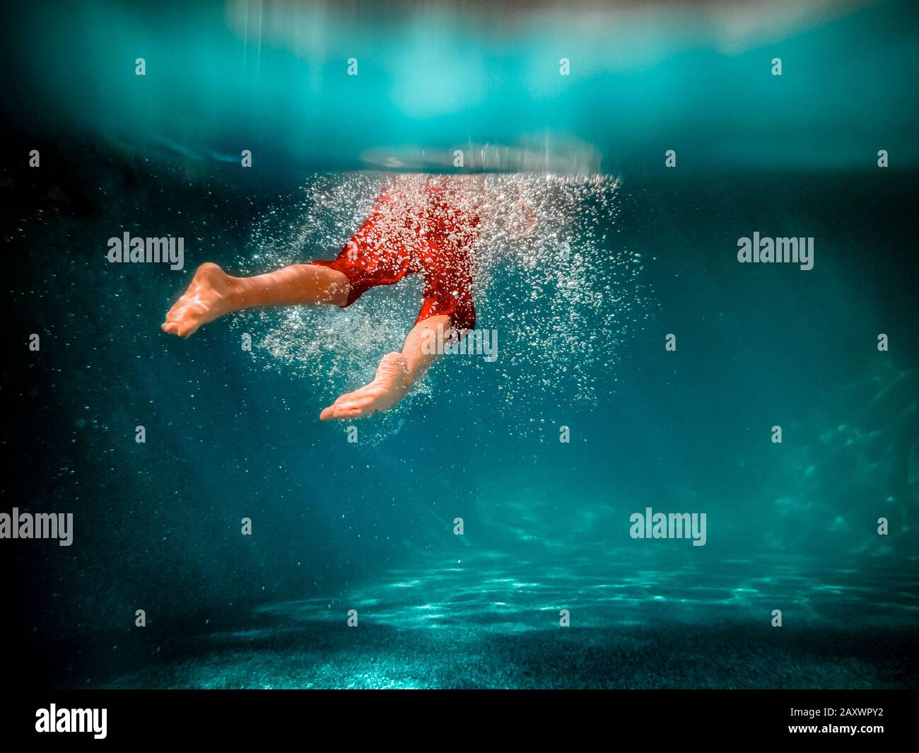 Imagen submarina de un niño nadando en una piscina Foto de stock
