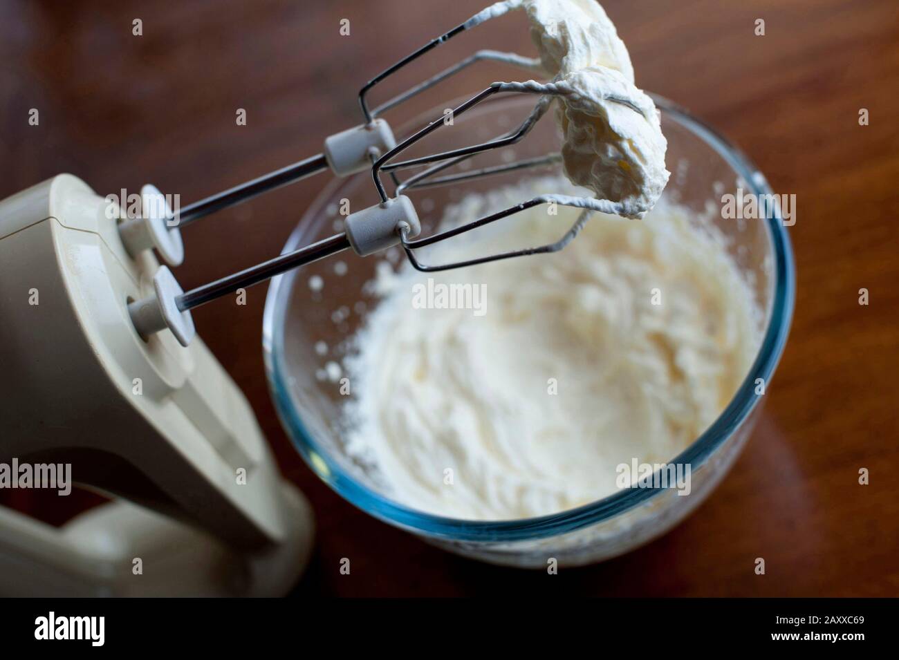 Batidora eléctrica de cocina con un accesorio para levantaclaras de metal  recubierto de nata espesa del recipiente de mezcla de cristal de abajo  Fotografía de stock - Alamy