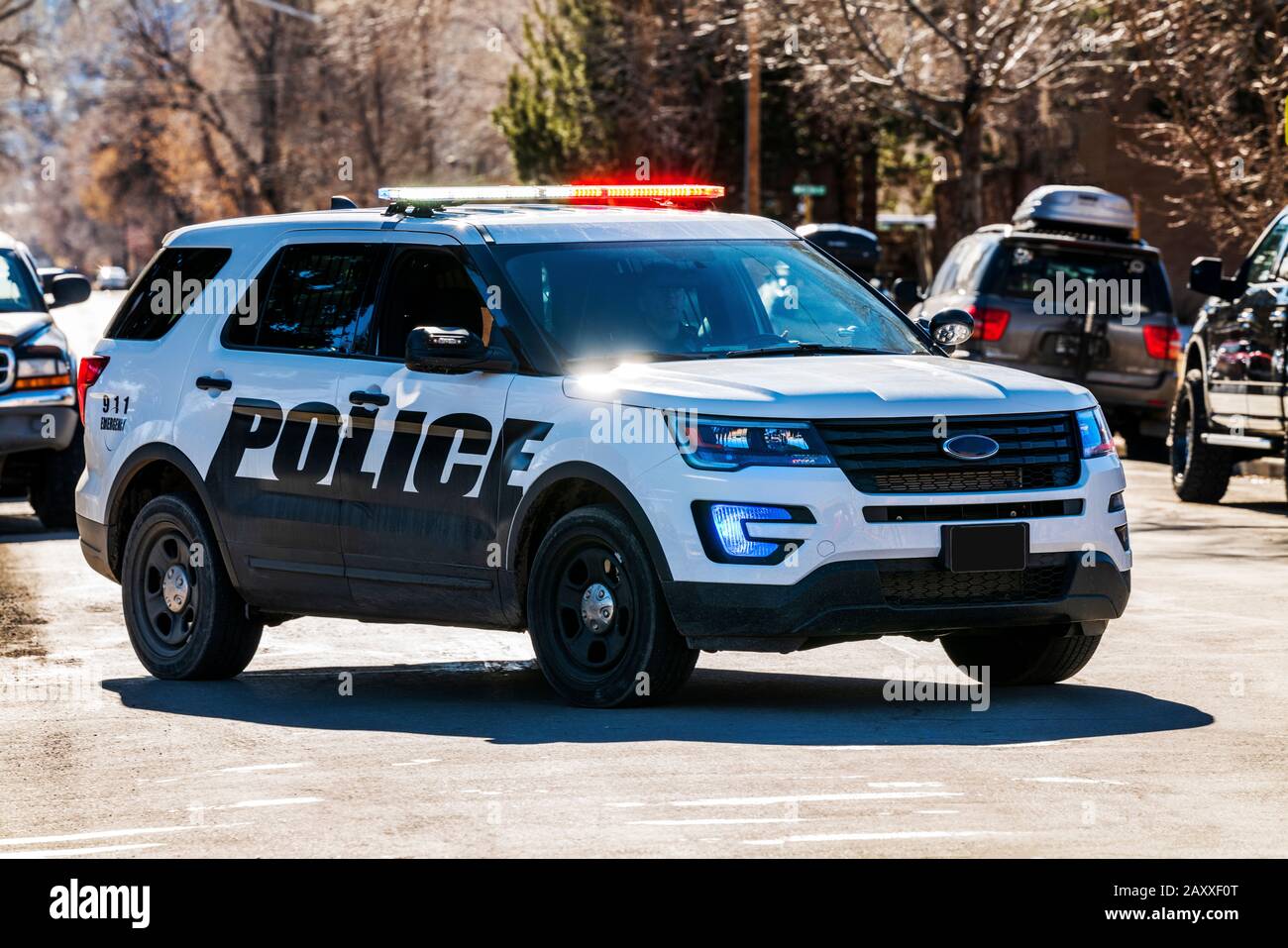 Coche de policía & luces; escolta un desfile en la pequeña ciudad de salida, Colorado, EE.UU. Foto de stock