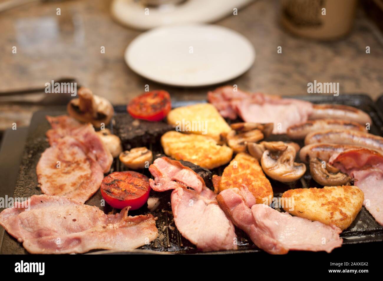 Cocina un abundante desayuno inglés en una plancha con tomate, tocino,  tostadas francesas y salchichas Fotografía de stock - Alamy