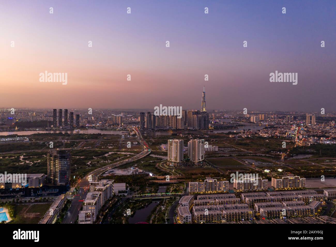 Vista aérea a los nuevos desarrollos inmobiliarios de lujo a lo largo del río Saigón desde el distrito de Jue Thiem, en Ciudad Ho Chi Minh, Vietnam al atardecer Foto de stock