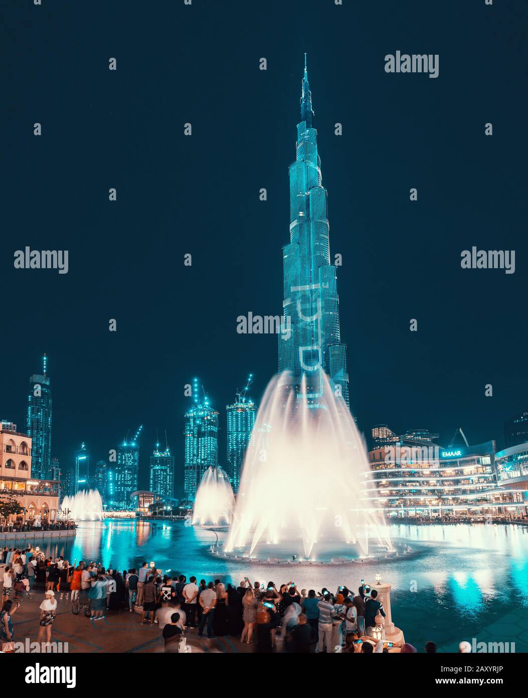 28 de noviembre de 2019, EAU, Dubai: Vista nocturna de la torre iluminada de Burj Khalifa y un estanque con una fuente de baile. Espectáculo popular y majestuoso en D. Foto de stock