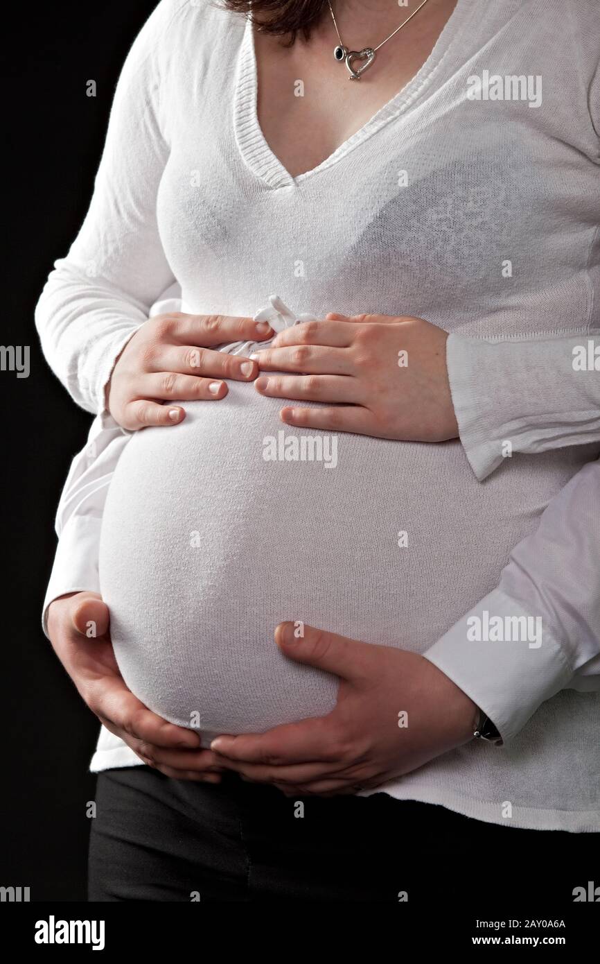 Manos sosteniendo el vientre de una mujer embarazada Foto de stock