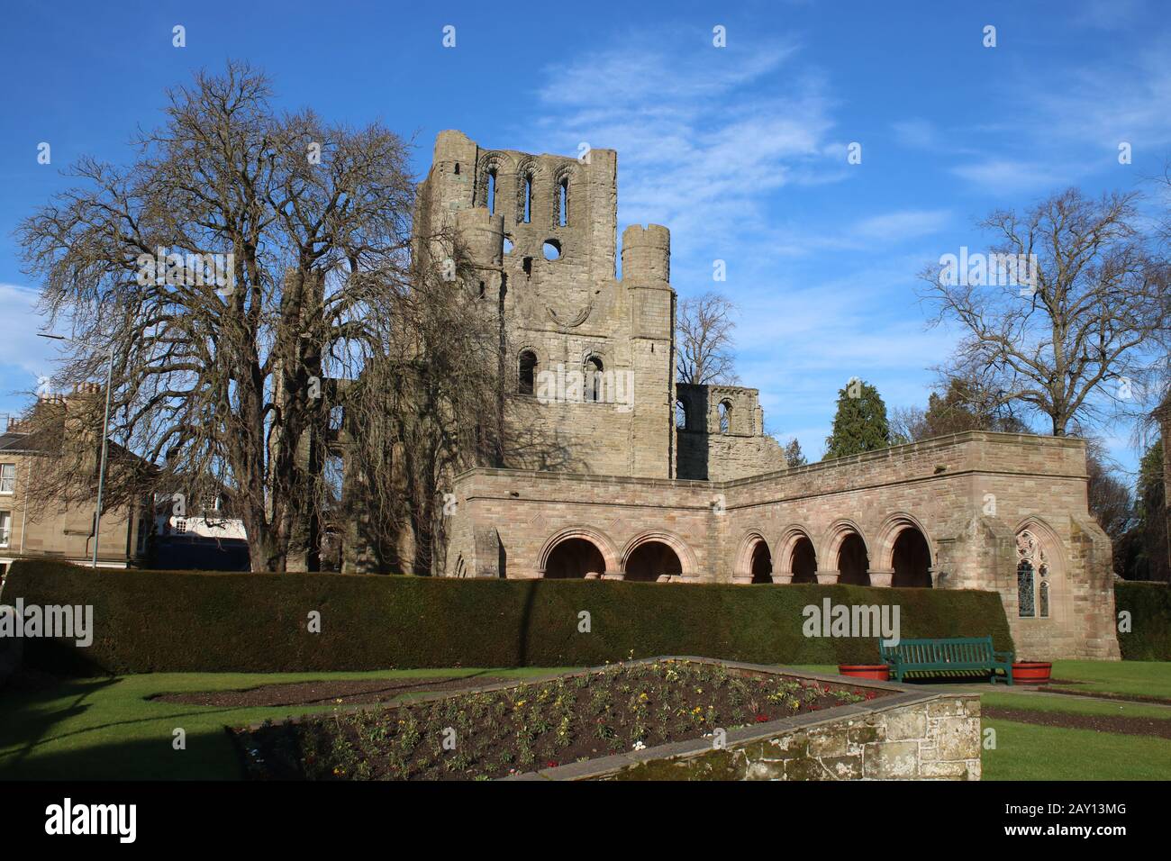 Restos de los claustros en la Abadía de Keslo con las ruinas de la Torre Oeste de la Abadía en el fondo visto desde el jardín Memorial de Guerra adyacente. Foto de stock