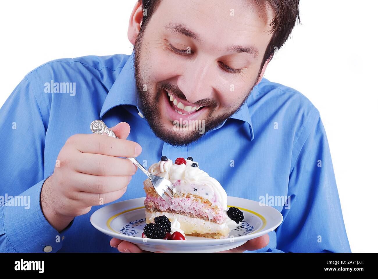 Hombre joven comiendo pastel colorido Fotografía de stock - Alamy