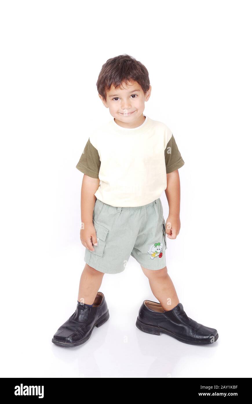 Un niño pequeño está parado en zapatos para adultos Fotografía de stock -  Alamy