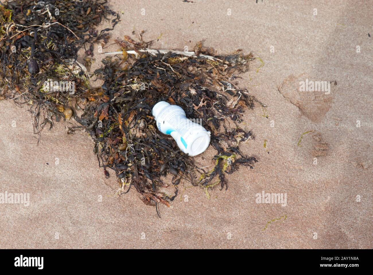 Botella de plástico blanco en la playa de Hebridean Foto de stock