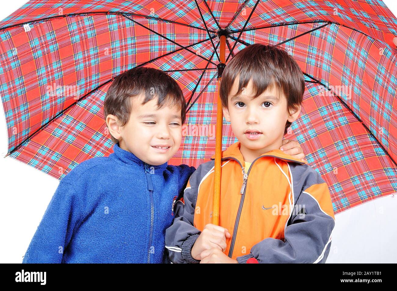 Chicos muy lindos en ropa de otoño y con paraguas aislado Fotografía de  stock - Alamy
