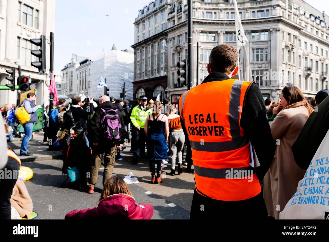 Londres, Reino Unido. Un manifestante con un tabard naranja con 'Legal Protester' escrito en él observa una protesta en Oxford Circus. Londres se paraliza Foto de stock