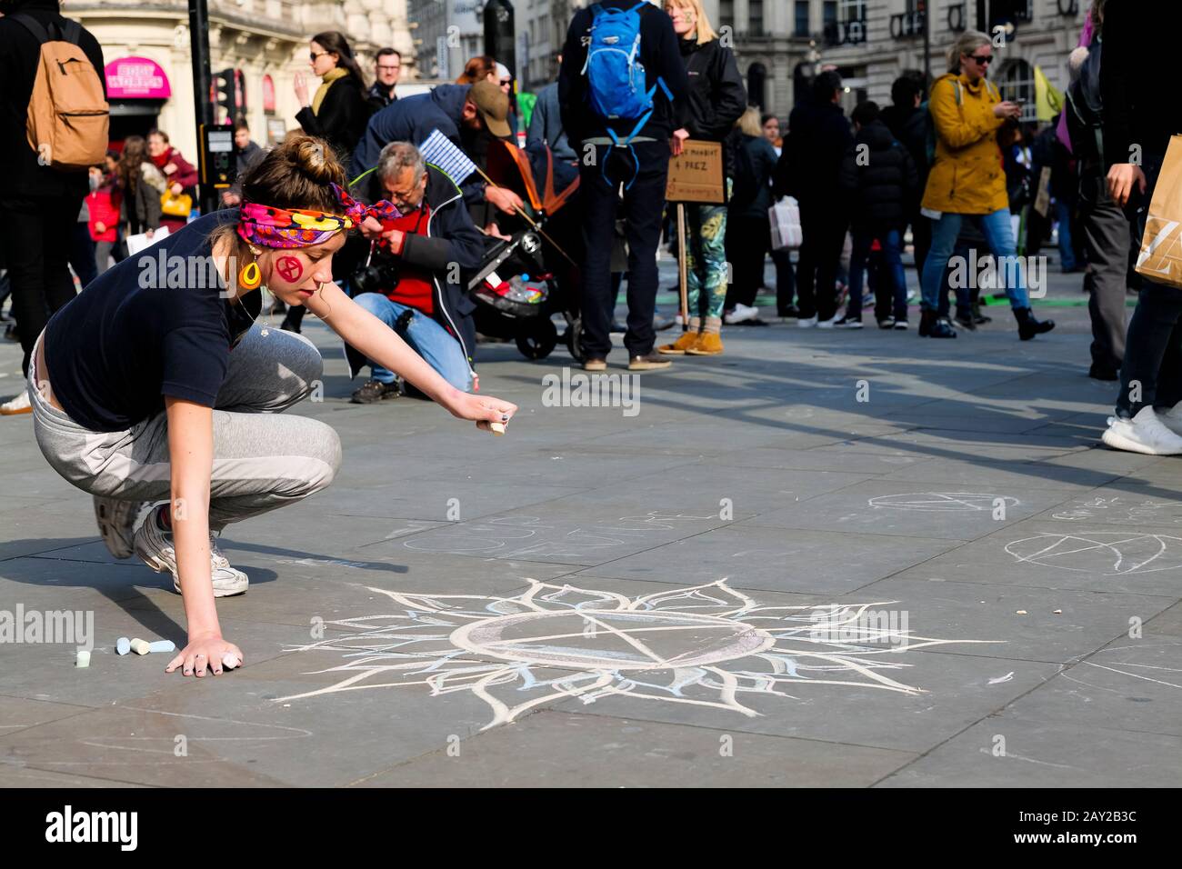 Londres, Reino Unido. Una joven se dibuja con tiza en Picadilly Circus mientras Londres se detiene mientras protestan con el cró de protesta Rebellion De Extinción Foto de stock