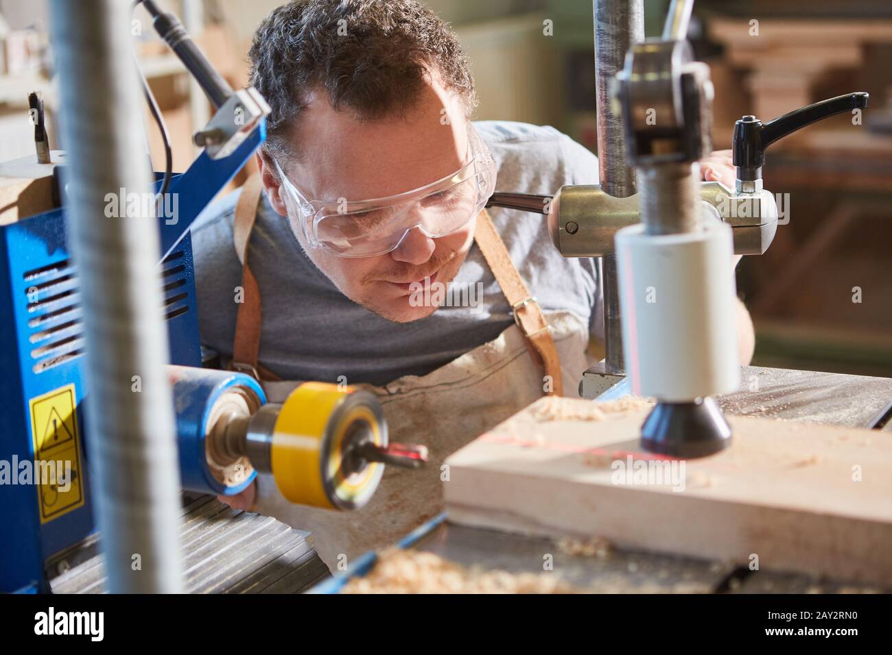 Carpintero con gafas de seguridad al taladrar madera con un taladro láser  Fotografía de stock - Alamy