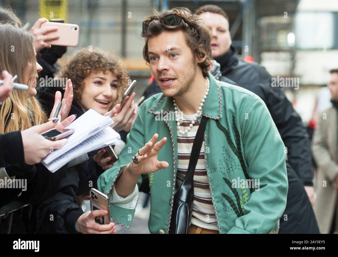 Harry Styles habla con los fans mientras sale de los estudios de BBC Radio  en Londres, después de una aparición en el Zoe Ball Breakfast Show de Radio  2 Fotografía de stock -