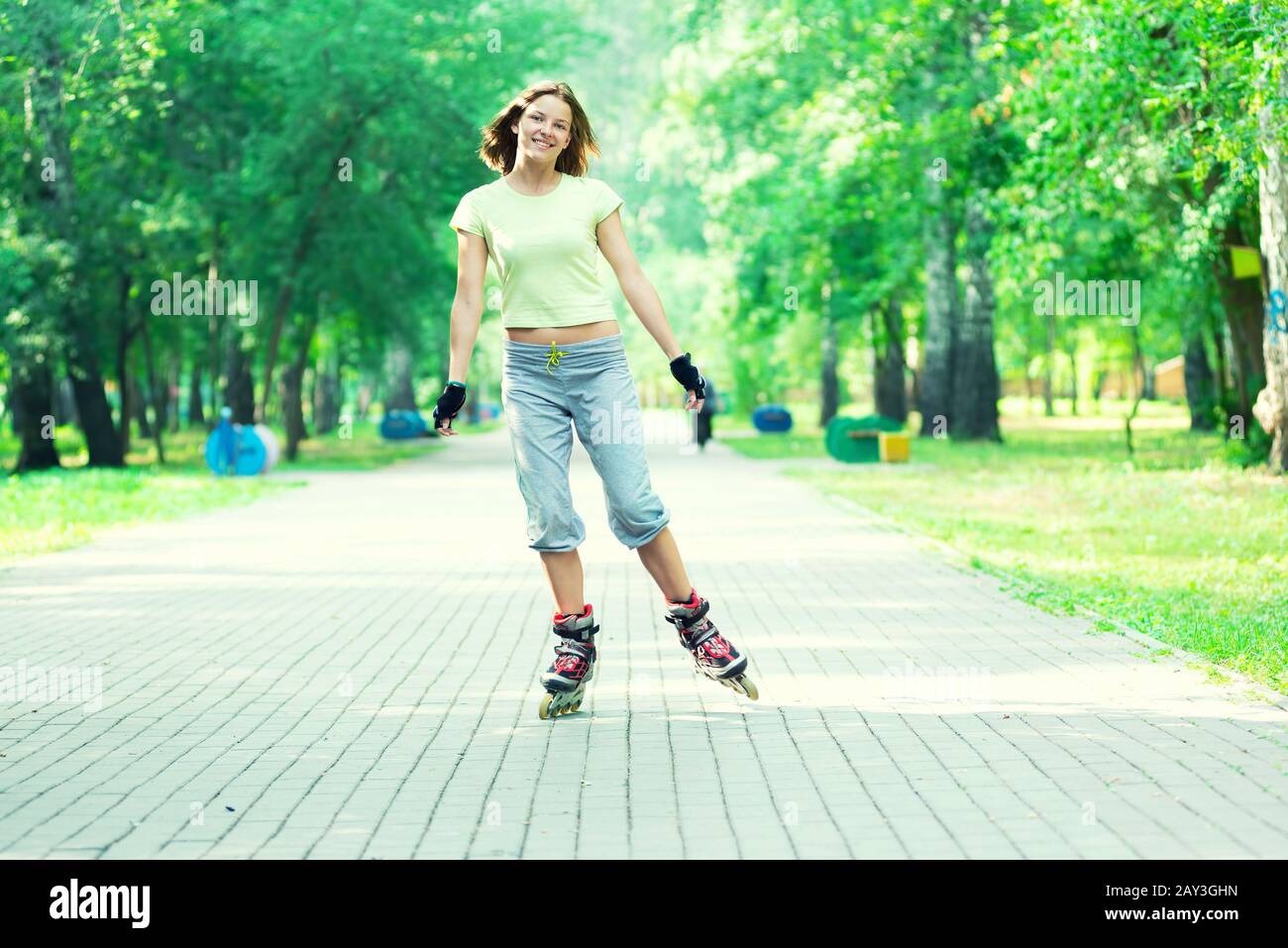 Patinar en el parque deportivo de chica patinar sobre patines en línea Foto de stock