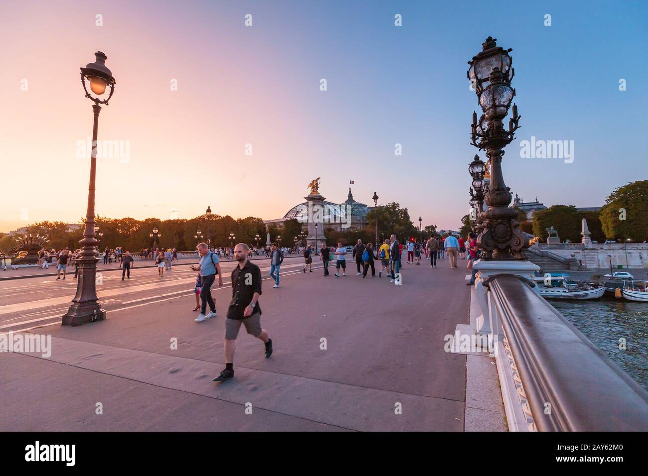 28 de julio de 2019, París, Francia: La gente camina por el puente Alejandro III durante una brillante puesta de sol sobre el Sena. Viaje a París Foto de stock