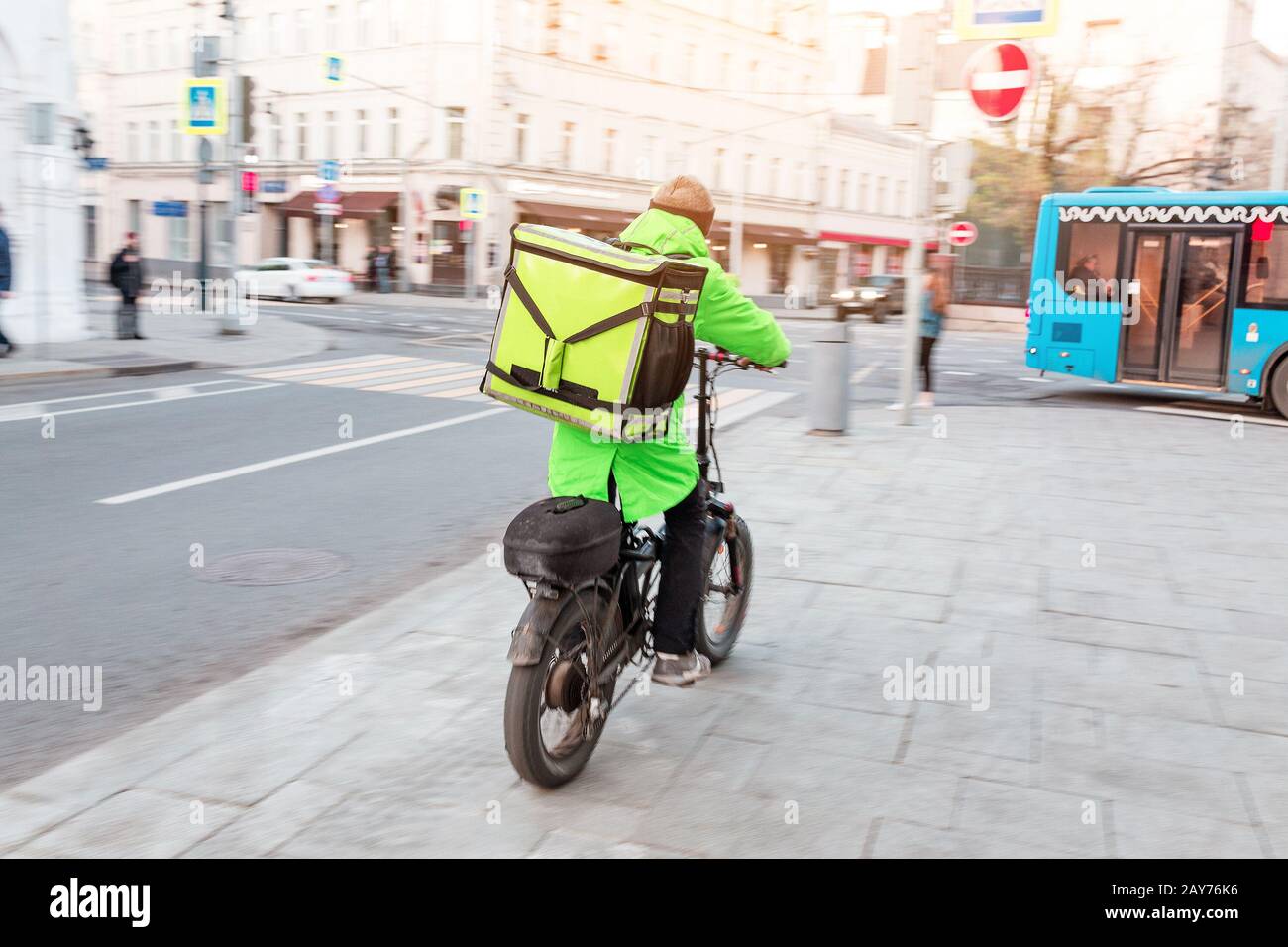 Hombre de reparto con mochila llena de comida sabrosa montando en bicicleta  en la acera, efecto de movimiento borroso Fotografía de stock - Alamy