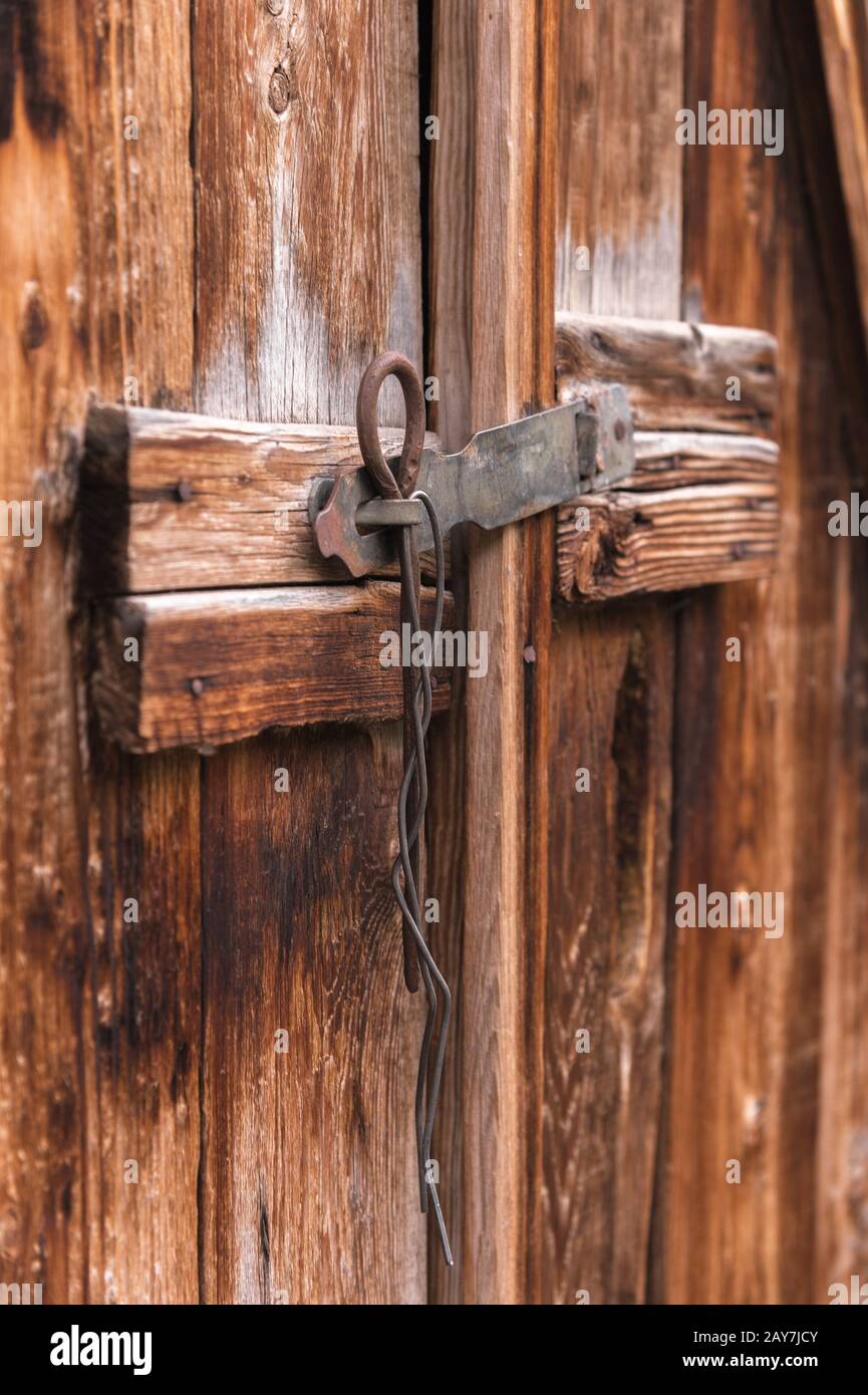 antigua cerradura simple en una puerta de madera cerrada con un pasador  metálico pestillo rústico en una puerta antigua de madera Fotografía de  stock - Alamy