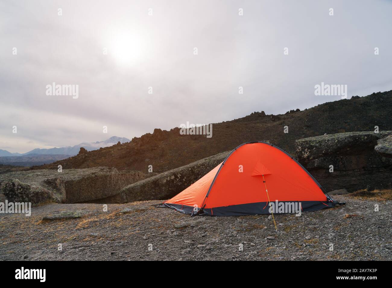 Una carpa naranja de gran altitud está situada en lo alto de las montañas, sobre el fondo de la cresta caucásica Foto de stock