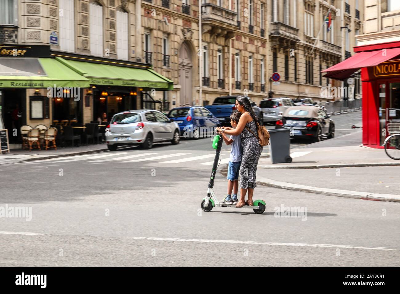 Mujer y niño Ride electric scooter en París, Francia Europa Foto de stock