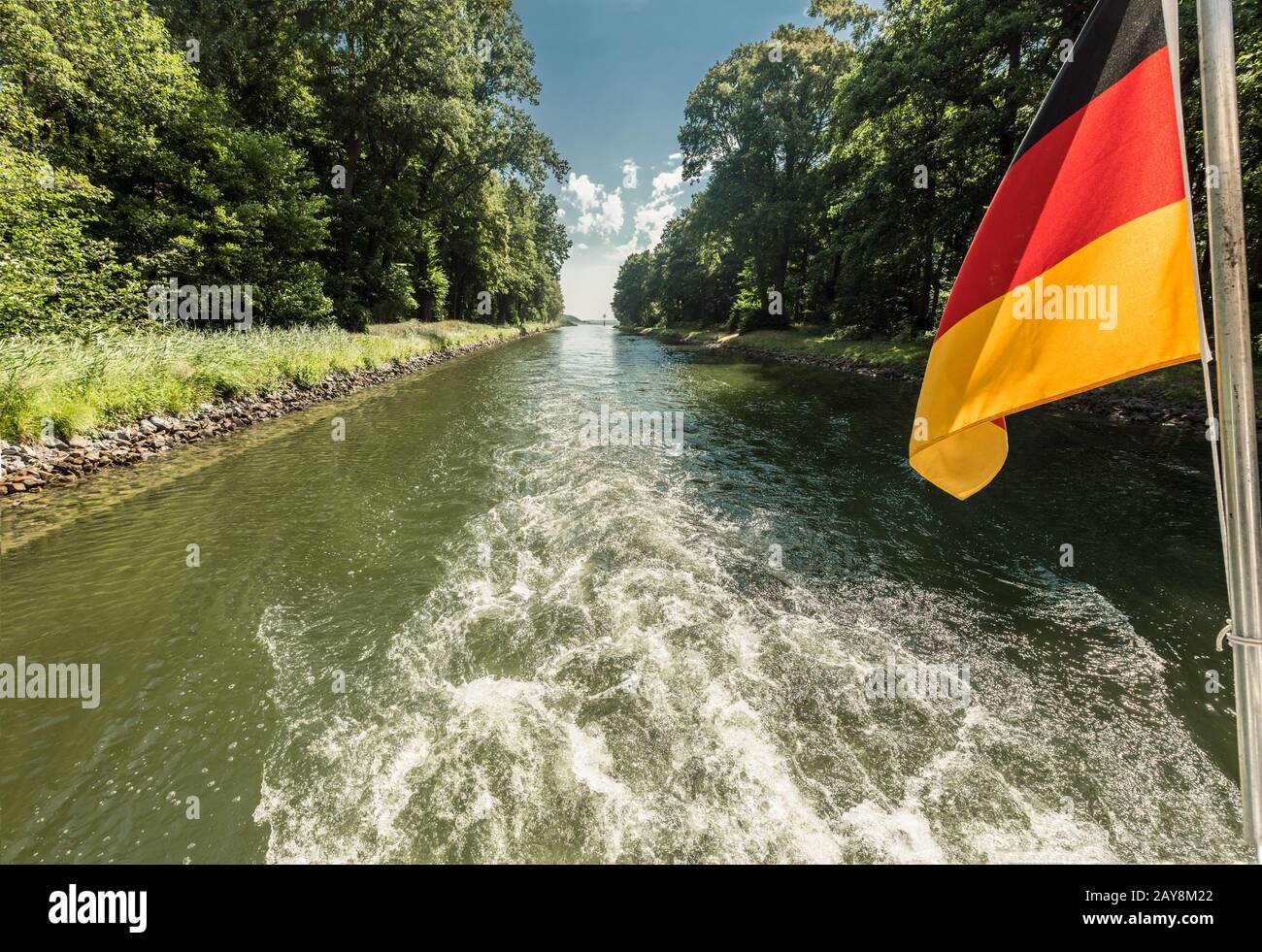 Eje de transmisión de un barco en un canal que paso con ondeando la bandera de Alemania Foto de stock