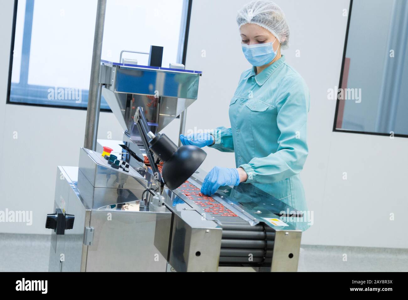 Farmacia industria ropa mujer trabajadora en la producción de tabletas de funcionamiento en condiciones de trabajo estériles Foto de stock
