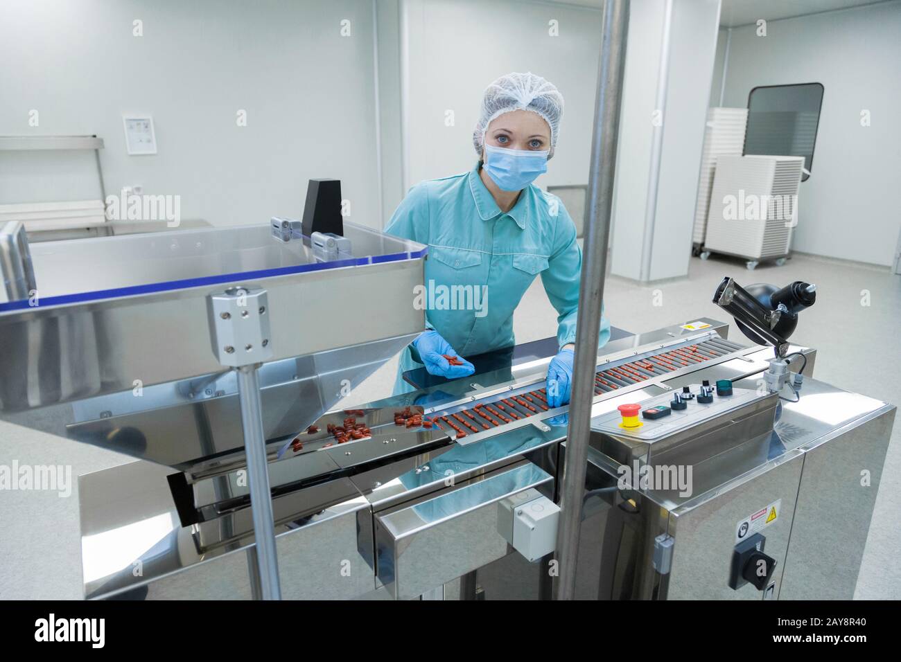 Farmacia industria ropa mujer trabajadora en la producción de tabletas de funcionamiento en condiciones de trabajo estériles Foto de stock