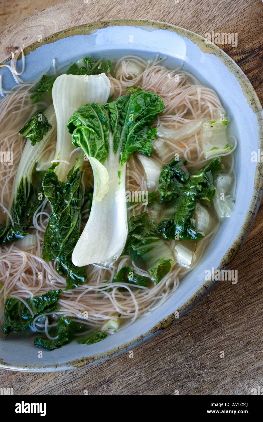 Sopa Pak choi con los platos de los platos Foto de stock